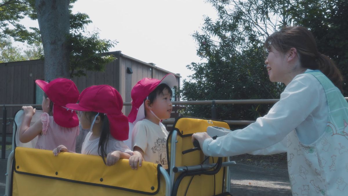 おさんぽ中に子どもたちに笑顔で話しかける保育士